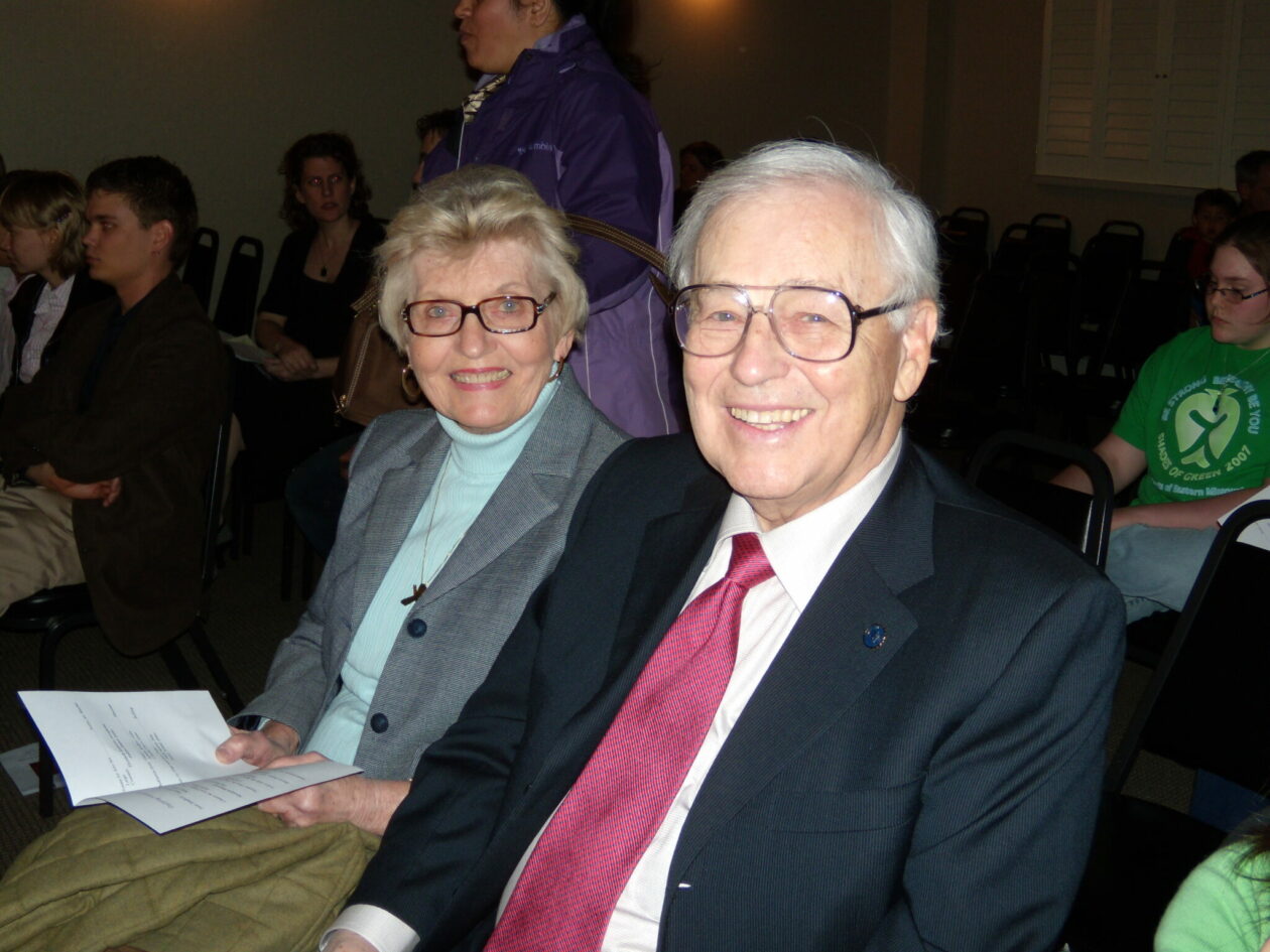 Steve Jobs w czarnym golfie trzymający jabłko przed publicznością