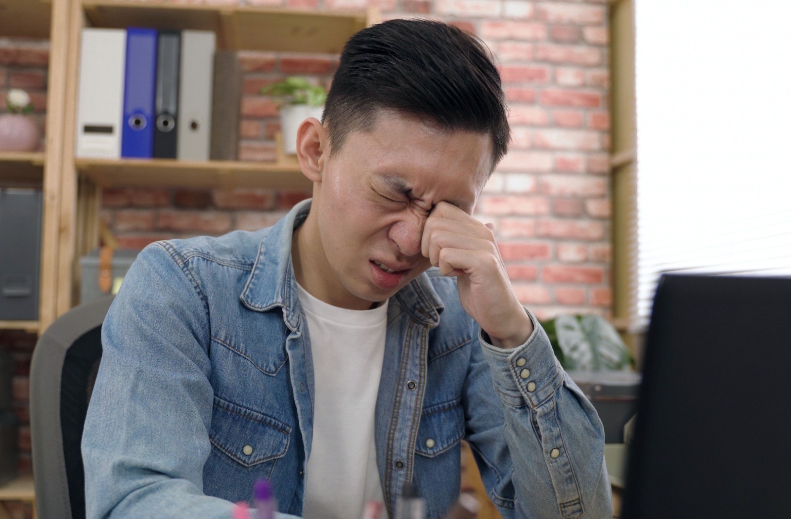 mężczyzna trzymający książkę w odległości trzydziestu centymetrów od twarzy